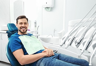 Bearded man sitting in dental chair and smiling