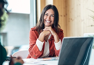 Woman smiling while looking at colleague at work